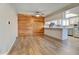 Open dining area with wood accent wall and hardwood floors flowing into the kitchen with white cabinetry and stainless steel appliances at 9501 W 89Th Cir, Broomfield, CO 80021