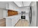 Bright kitchen features white cabinetry, stainless appliances, and a wood accent wall at 9501 W 89Th Cir, Broomfield, CO 80021