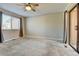 The main bedroom features neutral carpet, a ceiling fan, a window with curtain accents, and a sliding glass door at 9501 W 89Th Cir, Broomfield, CO 80021