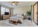 Neutral main bedroom featuring a ceiling fan, ample natural light, a dresser, and a sliding glass door with curtain accents at 9501 W 89Th Cir, Broomfield, CO 80021