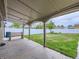 Covered patio overlooking a spacious backyard with grass, a white fence, and a wooden bench at 5481 Xanadu St, Denver, CO 80239