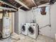 Basement laundry area with washer, dryer, water heater and exposed ductwork at 5481 Xanadu St, Denver, CO 80239