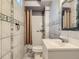 Bathroom featuring tiled walls, decorative accents, shower stall, and sink with vanity at 5481 Xanadu St, Denver, CO 80239