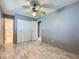 Bedroom with laminate floors, white closet doors, and bathroom access at 5481 Xanadu St, Denver, CO 80239