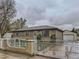 View of home's exterior with a brick and wrought iron fence and detached garage at 5481 Xanadu St, Denver, CO 80239