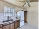 Well-lit kitchen with double basin sink, tile backsplash, and retro ceiling fan at 5481 Xanadu St, Denver, CO 80239