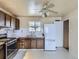 Cozy kitchen featuring tile floors, white appliances, and wood cabinets at 5481 Xanadu St, Denver, CO 80239