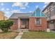 Charming brick home featuring a cozy front porch and well-maintained landscaping at 1425 Xavier St, Denver, CO 80204