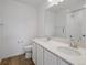 Bathroom with dual sinks, tile shower, and wood floors at 45909 Wood Thrush Ave, Bennett, CO 80102