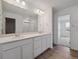 Bathroom featuring a dual sink vanity, quartz countertops, and wood floors at 45909 Wood Thrush Ave, Bennett, CO 80102