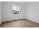 Bright, light-filled bedroom features wood-look floors and view of new construction at 45909 Wood Thrush Ave, Bennett, CO 80102