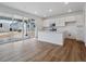 Open kitchen with island, white cabinets, stainless appliances and patio views at 45909 Wood Thrush Ave, Bennett, CO 80102