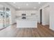 Eat-in kitchen with island, stainless appliances, white cabinetry and glass doors to patio at 45909 Wood Thrush Ave, Bennett, CO 80102