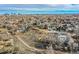 Aerial view showcases a neighborhood with a mix of homes and green spaces and downtown on the horizon at 34 S Raleigh St, Denver, CO 80219