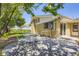 Backyard featuring a brick house, mature trees, a spacious patio, and ample green space at 34 S Raleigh St, Denver, CO 80219