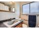 Bathroom with white tile walls and a wood trimmed mirror above the vanity at 34 S Raleigh St, Denver, CO 80219