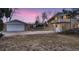 Exterior view of brick home featuring a detached garage and a large, fenced yard at 34 S Raleigh St, Denver, CO 80219