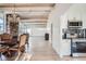 Open living area boasts exposed beam ceiling, a stone accent wall, and an adjacent white kitchen at 34 S Raleigh St, Denver, CO 80219