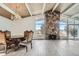 Bright living room boasting a stone fireplace, wood ceiling beams, and large windows with a beautiful view at 34 S Raleigh St, Denver, CO 80219