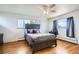 Comfortable main bedroom features beautiful hardwood floors, a large window, and a ceiling fan at 34 S Raleigh St, Denver, CO 80219