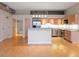 Open kitchen with a kitchen island, stainless steel appliances, and light wood cabinets at 7110 W Alaska Dr # A, Lakewood, CO 80226