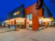 A view of G-Que BBQ with outdoor seating and signage at night at 7110 W Alaska Dr # A, Lakewood, CO 80226