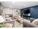 Finished basement lounge with plush sectional sofa, decoratively painted blue wall, and stylish decor at 1290 S Elizabeth St, Denver, CO 80210