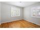 Empty bedroom with hardwood floors, white walls, and bright natural light from two shuttered windows at 1290 S Elizabeth St, Denver, CO 80210