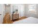 Bedroom featuring hardwood floors, white walls, a wooden dresser, and a view down the hallway at 1290 S Elizabeth St, Denver, CO 80210