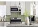 Bright kitchen with white cabinets, stainless steel appliances, decorative backsplash, and stylish pendant lighting at 1290 S Elizabeth St, Denver, CO 80210