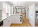 Stylish kitchen with granite counters, white cabinets, stainless appliances, and open flow to the living area at 1290 S Elizabeth St, Denver, CO 80210