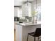Close up of kitchen island with granite countertop, pendant lights, white cabinets and mosaic tile backsplash at 1290 S Elizabeth St, Denver, CO 80210