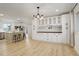 Spacious kitchen featuring white cabinets, hardwood floors, modern lighting, and stainless steel appliances at 2166 Appaloosa Trl, Elizabeth, CO 80107