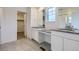 Modern bathroom with double sinks, white cabinetry, and gray tile flooring at 28625 E 6Th Pl, Watkins, CO 80137