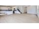 Open-concept living space with hardwood floors, white walls, and a modern kitchen in the background at 28625 E 6Th Pl, Watkins, CO 80137