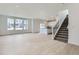 Bright and airy living room featuring hardwood floors, large windows, and access to the kitchen and staircase at 28625 E 6Th Pl, Watkins, CO 80137