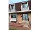 Charming townhome with brick facade, blue door, red rock landscaping, and unique dormer windows at 528 S Youngfield Ct, Denver, CO 80228