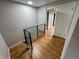 Hallway featuring modern railings and hardwood floors, leading to other rooms at 528 S Youngfield Ct, Denver, CO 80228