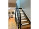Modern staircase with hardwood steps and a black metal railing, leading from the kitchen to the upper level at 528 S Youngfield Ct, Denver, CO 80228