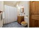 Bright bathroom featuring a shower with a white curtain, toilet, and vanity with a wooden cabinet at 3581 Gap Rd, Golden, CO 80403
