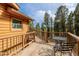 Inviting outdoor deck with wooden railings and patio seating overlooking a lush forest at 3581 Gap Rd, Golden, CO 80403