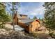 Stunning log home featuring a deck and gray roof nestled within a lush, mountainous landscape at 3581 Gap Rd, Golden, CO 80403