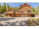 Stunning log home with decks and a two-car garage, surrounded by lush trees and an open driveway at 3581 Gap Rd, Golden, CO 80403