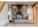 Close-up of a grand stone fireplace with a rustic design and hearth with wood storage at 3581 Gap Rd, Golden, CO 80403