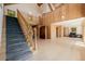 Bright living room with a staircase, wood paneling, hardwood floors, and a vaulted ceiling at 3581 Gap Rd, Golden, CO 80403