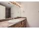 Bathroom featuring a decorative mirror and a tiled countertop at 3558 S Depew St # 302, Denver, CO 80235