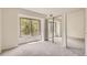 Bright bedroom featuring a large window with sliding mirrored closet doors, and gray carpet at 3558 S Depew St # 302, Denver, CO 80235
