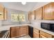 Bright kitchen featuring wood cabinets, tile backsplash, and modern appliances at 3558 S Depew St # 302, Denver, CO 80235