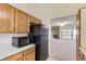 Kitchen featuring a black refrigerator, microwave, and a view of the living room at 3558 S Depew St # 302, Denver, CO 80235