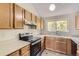 Well-lit kitchen featuring wood cabinets, tiled backsplash, modern appliances, and ample counter space at 3558 S Depew St # 302, Denver, CO 80235
